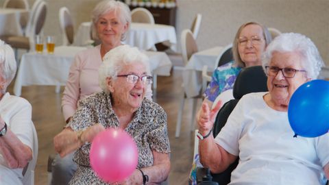 Elderly adults playing with balloons at a sports session