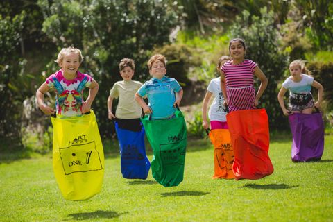 Children having a sack race at a sports birthday party