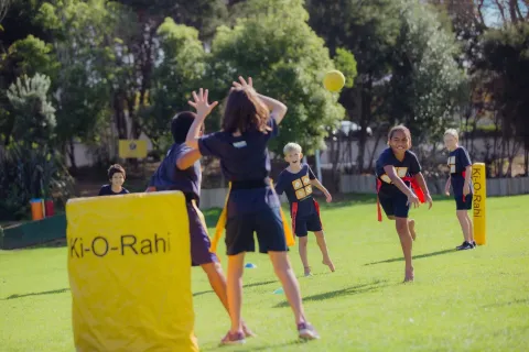 Children playing ki o rahi on a field